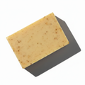LG Apothecary Co Bay Runner Botanical Bar Soap styled flat lay on white background, showcasing clean rectangular shape and subtle dark botanical flecks.