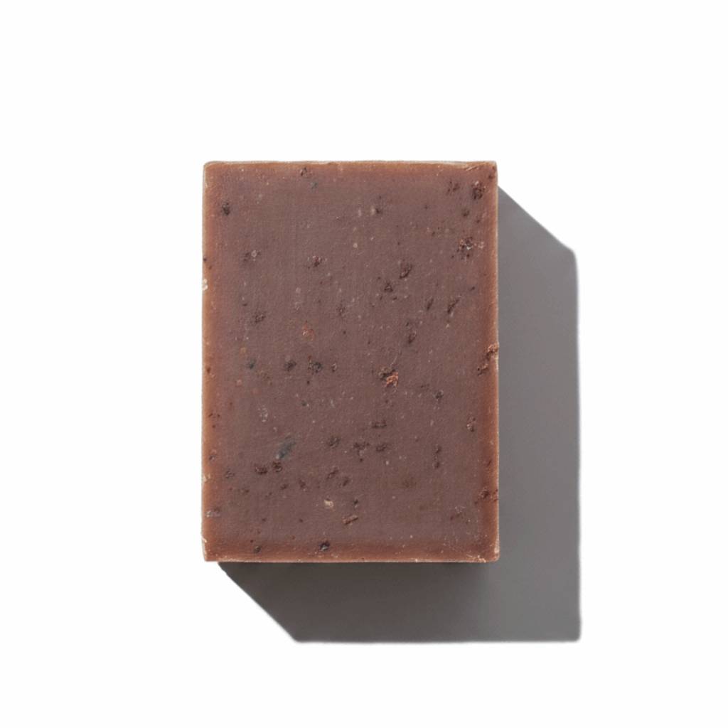 LG Apothecary Co. Vanilla Oatmeal Botanical Bar Soap, featuring a dense, chocolate-brown bar with visible oat flecks and a clean, straight-cut edge, resting on a crisp white background with a sharp, artistic shadow.