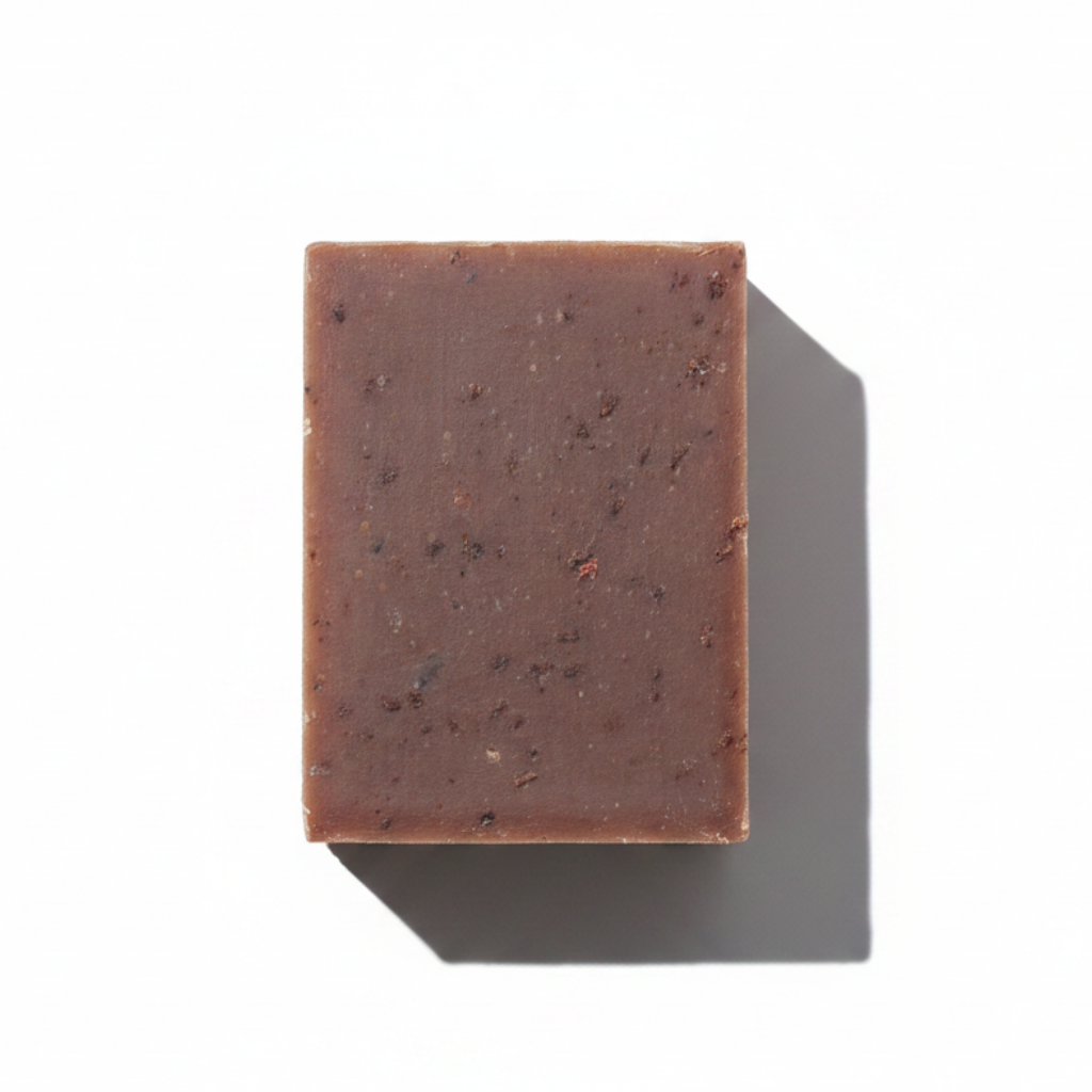 LG Apothecary Co. Vanilla Oatmeal Botanical Bar Soap, featuring a dense, chocolate-brown bar with visible oat flecks and a clean, straight-cut edge, resting on a crisp white background with a sharp, artistic shadow.